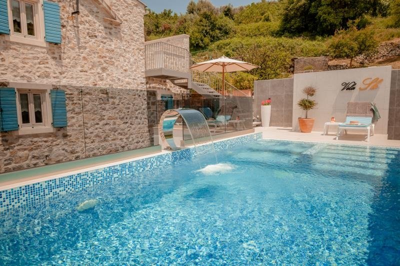 Tivat: This unique property is located right next to the sea and has its own beach and pool. 

Th villa consists of a living room with a fire place, dining r 